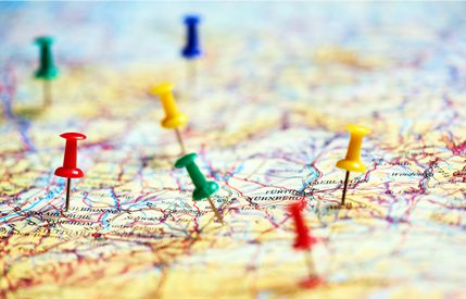 Map with several colorful push pins scattered across it, indicating the locations of various locations